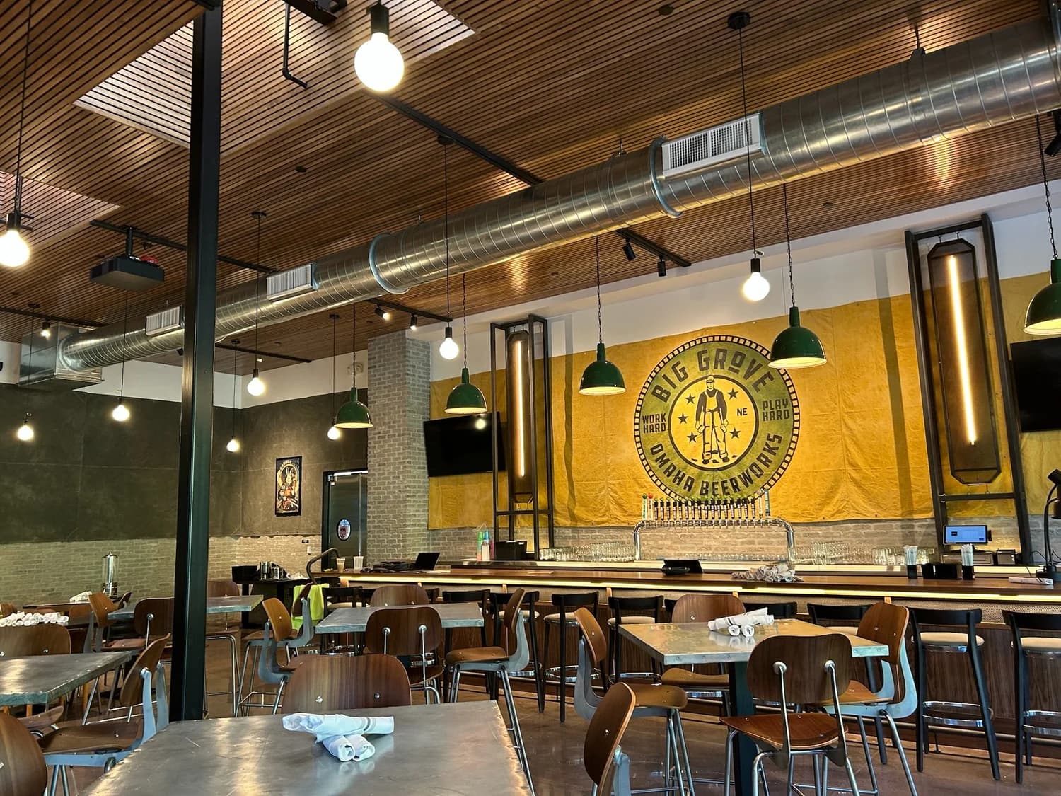 The Big Grove Brewery taproom in Omaha, with painted wood ceilings and a mural wall